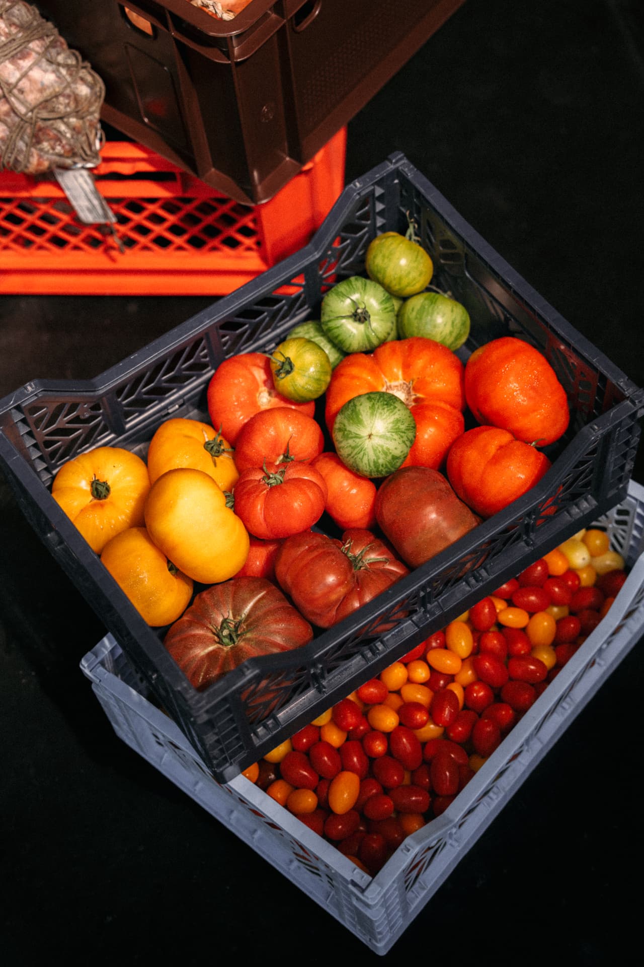 Kratten met verse tomaten in de keuken